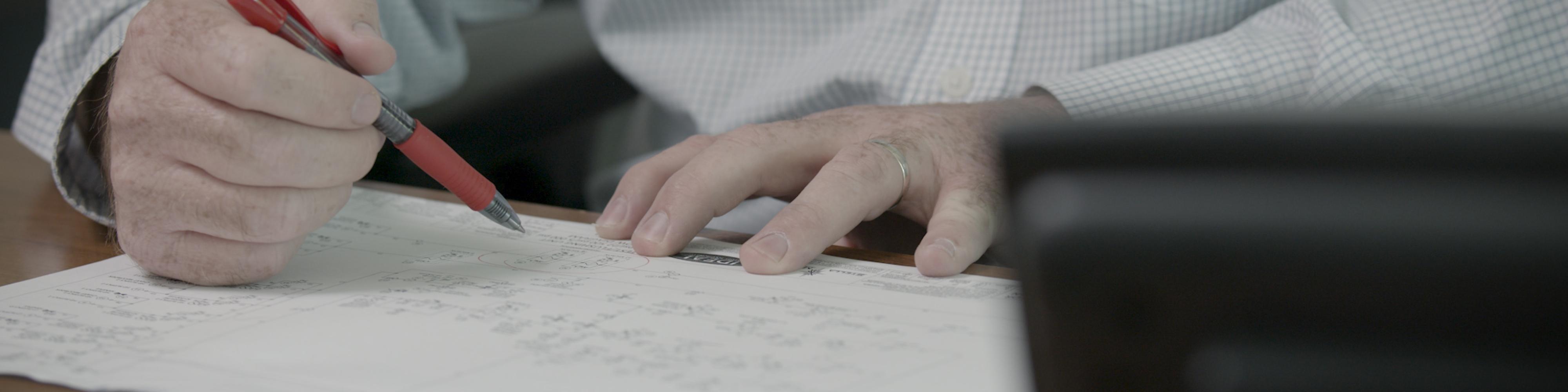 image of a person reviewing blue prints for a custom manufactured SKID