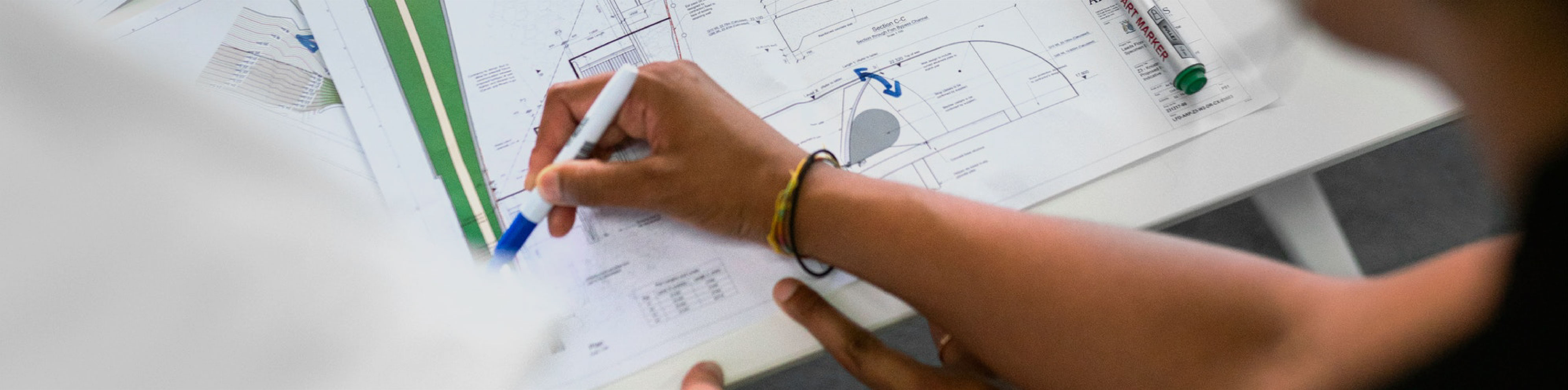 image of a person working on blue prints for a custom manufactured oil and gas system